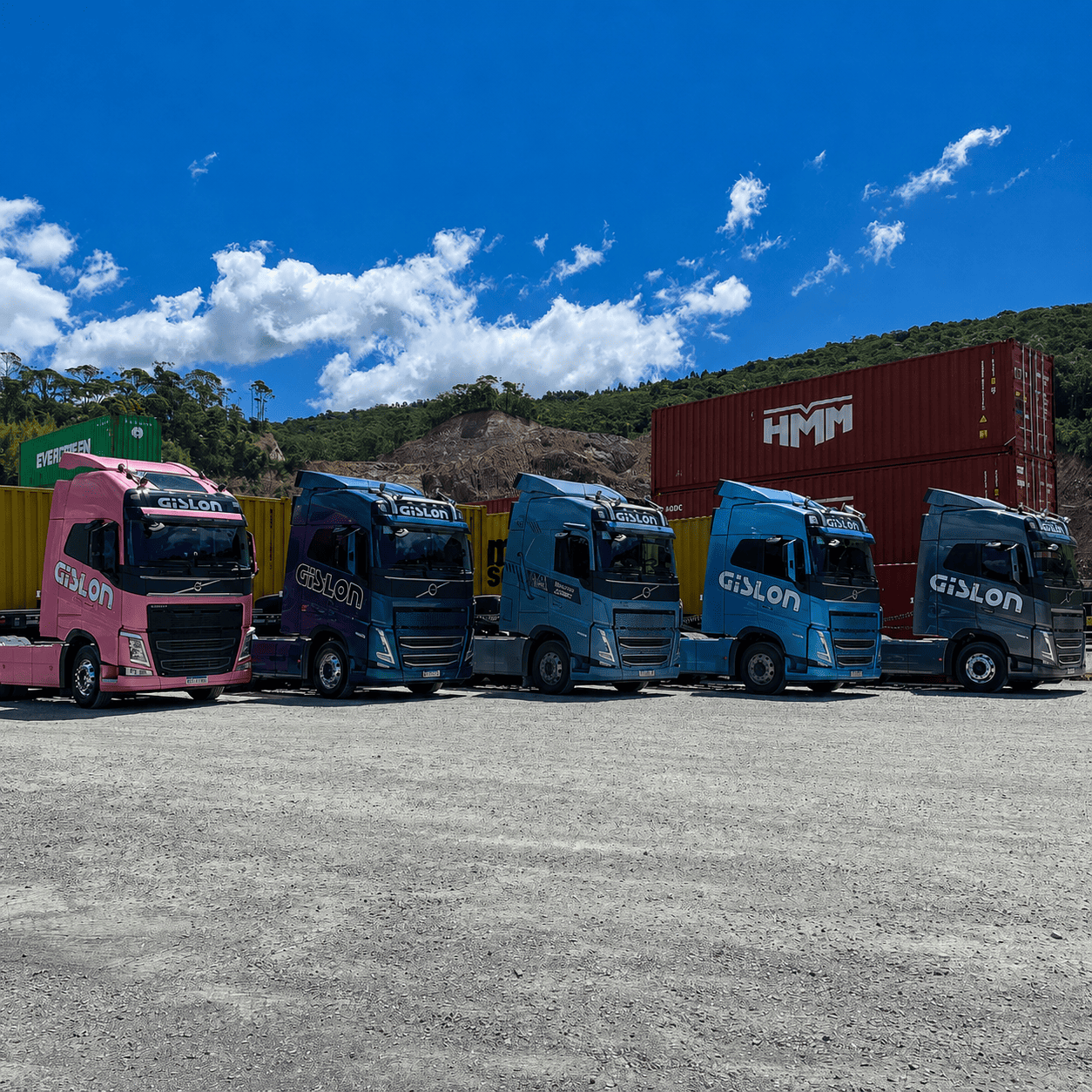Frota colorida de caminhões porta-contêineres da Gislon alinhada no pátio