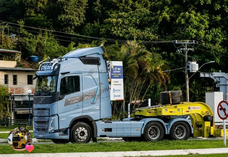 Caminhão Volvo azul da Gislon transportando maquinário